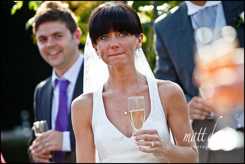Bride looking tearful during outdoor wedding speeches