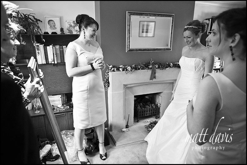 Bride looking in mirror with bridesmaids