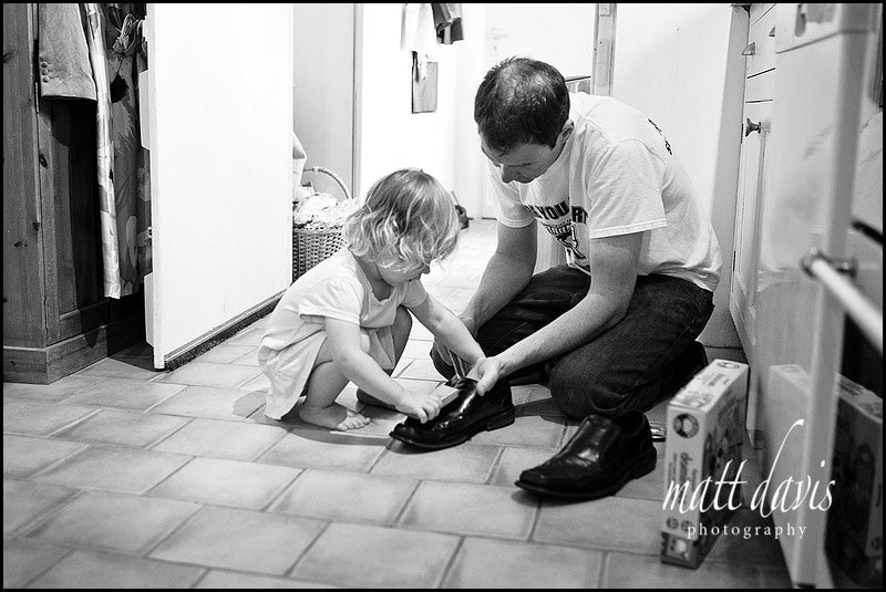 Child polishing shoes before wedding