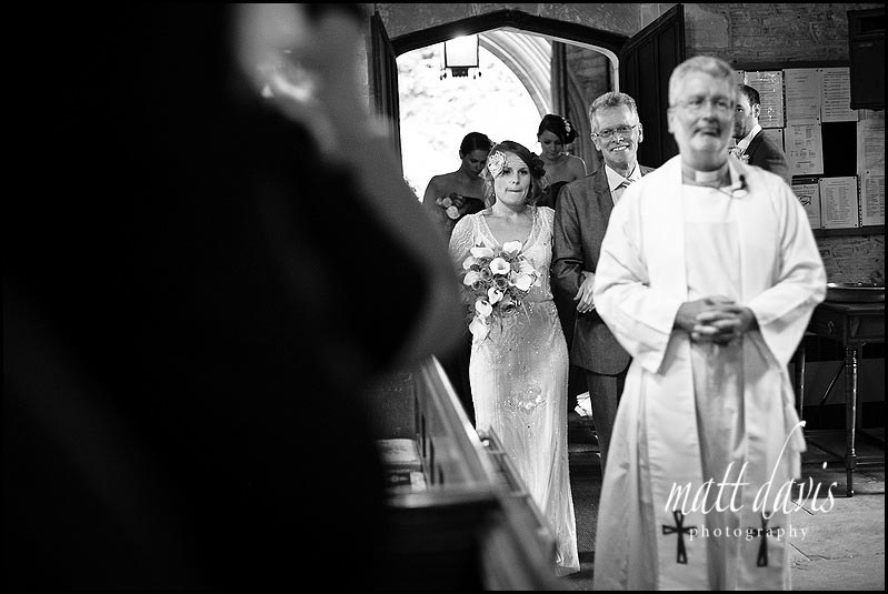Father and bride walking into Crudwell church for wedding