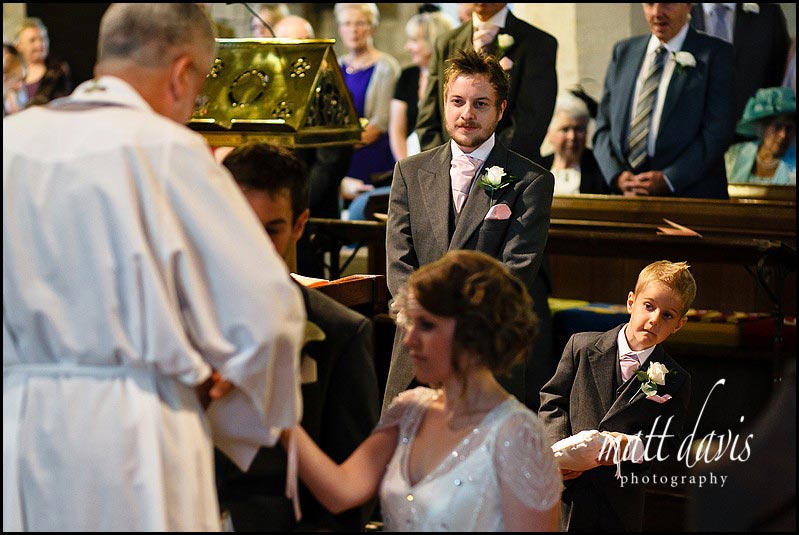 Ring bearer looking at wedding couple in Crudwell Church