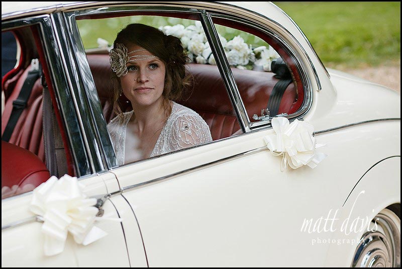 Vintage bride in cream vintage wedding car
