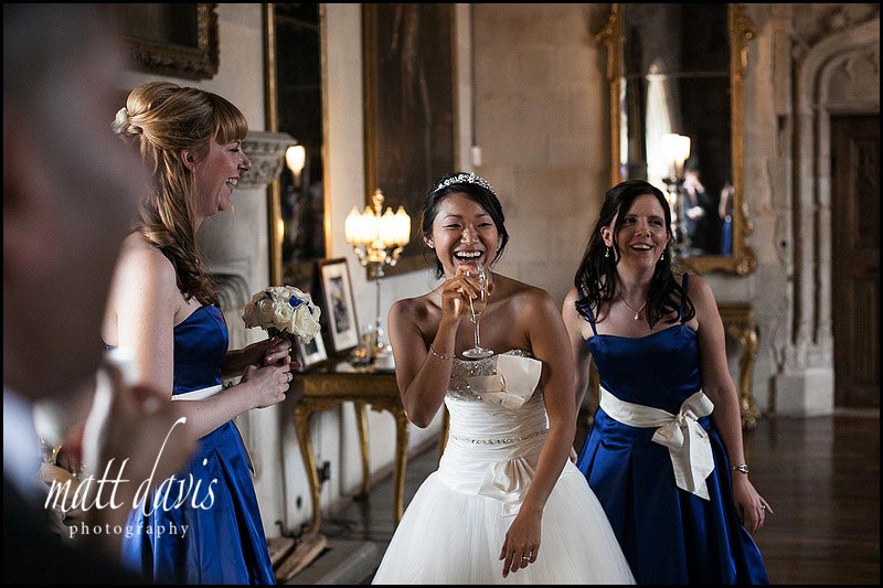 bride and bridesmaid laughing inside Berkeley Castle long drawing room