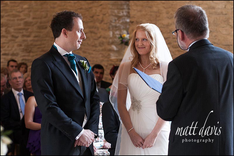 Kingscote Barn wedding photographs of bride and groom during wedding ceremony