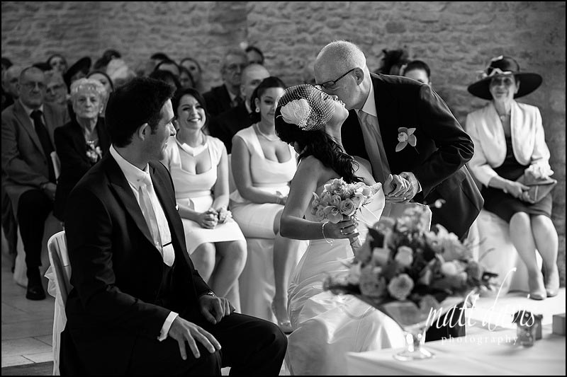 Father of the bride giving her away during a wedding ceremony at Kingscote Barn