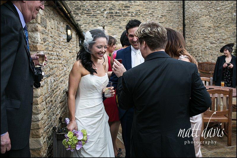 Bride being shown photos on wedding guests phone