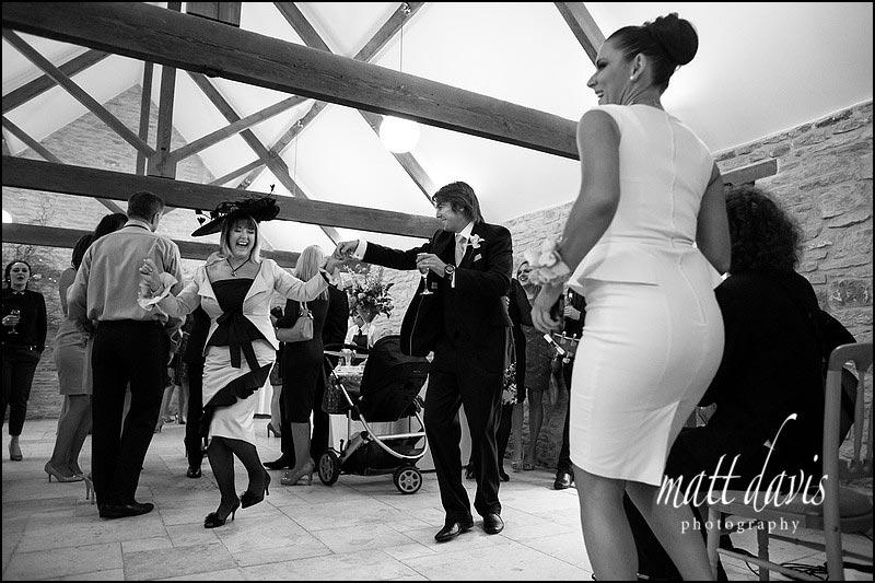 Mother of the bride dancing during a drinks reception at Kingscote Barn
