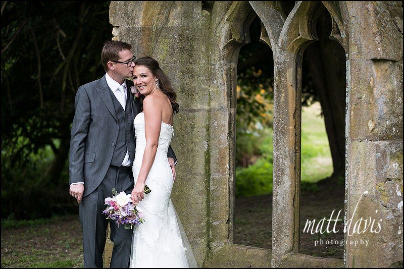 Dumbleton Hall Wedding Photos using the old church window in the gardens