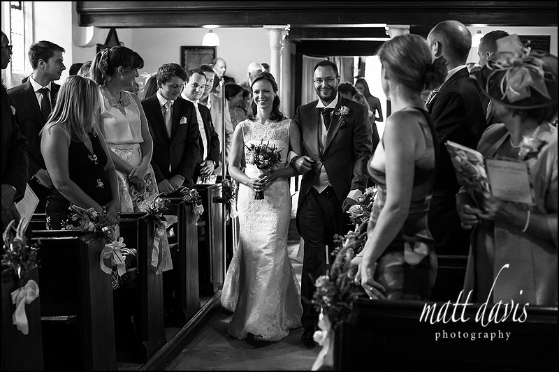 wedding photo inside Kingscote Church as the bride walks down the aisle.