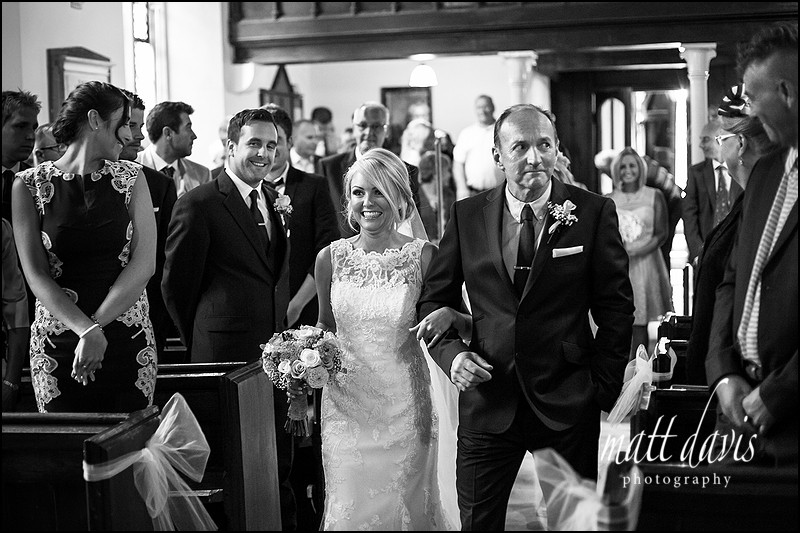 black and white photography inside Kingscote church showing brides arrival