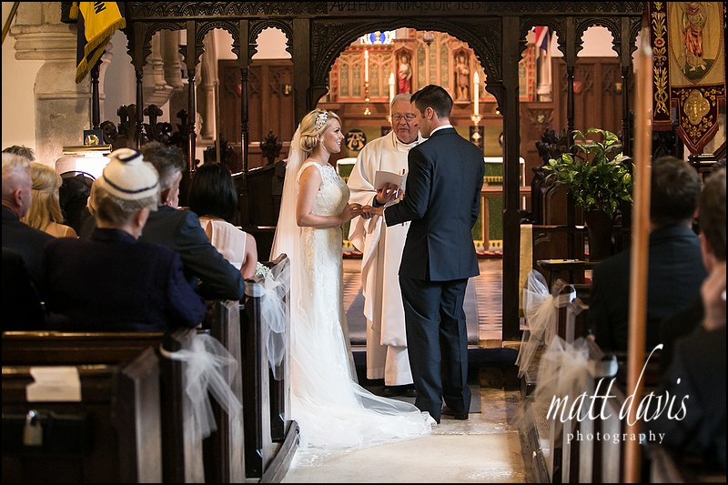 Wedding ceremony ring exchange at Kingscote Church