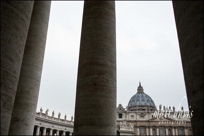 St. Peter's basilica photographed through the pillars surrounding it