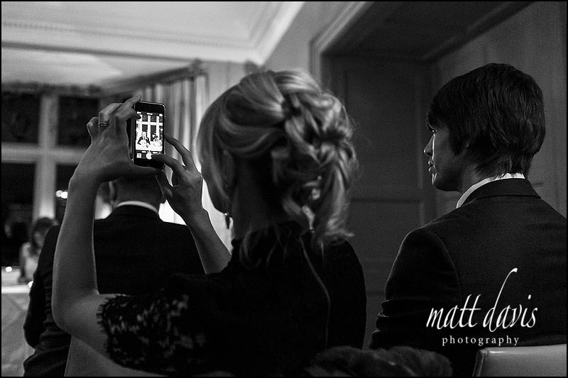 Documentary wedding photography capturing guests at Barnelsy House taking photos during the small wedding ceremony