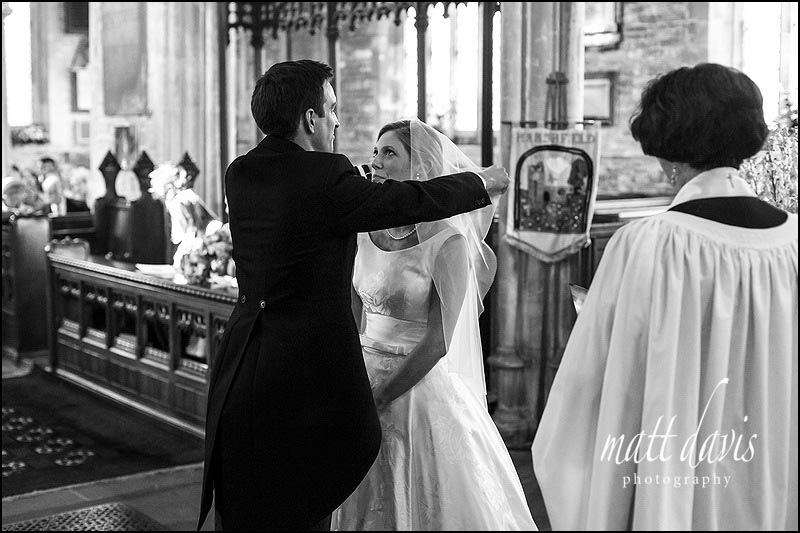 black & white documentary wedding photos taken during a wedding in Holy Trinity church, Cold Ashton, Gloucestershire