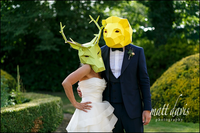 Fun couple wear coloured animal masks at their Manor By The Lake wedding 